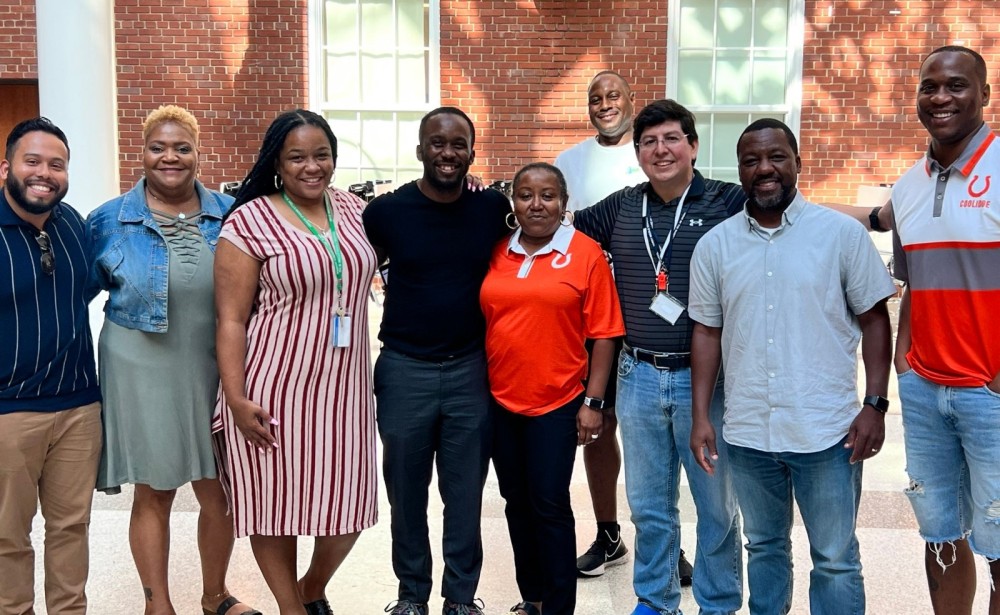 DCPS school leaders and staff smiling together in a school atrium